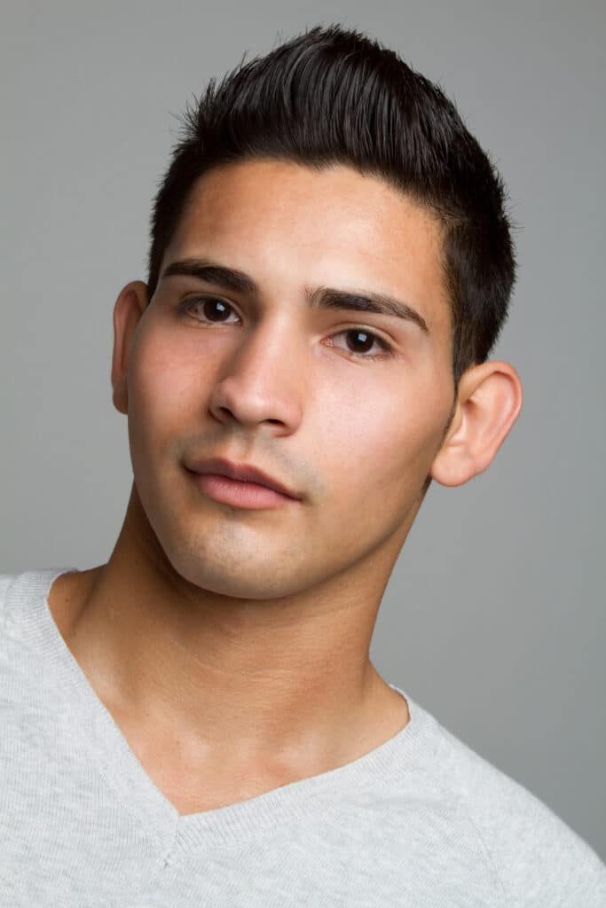 Young man closeup headshot with short dark hair and light gray shirt.
